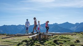 Der Erlebnispark Jochtal Kinder auf einem Holzspielzeug im Jochtal