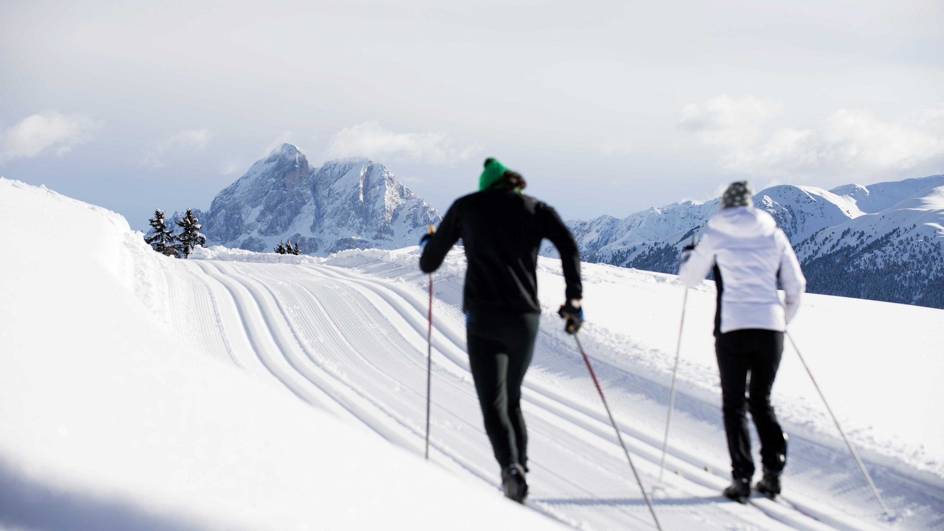 De Rodenecker-Lüsner Alm Twee langlaufers op besneeuwde piste met bergen