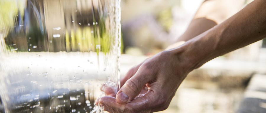 Vals: das Almendorf Hand fängt Wasser aus Wasserfall auf