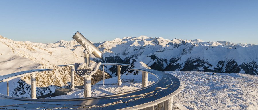 Find your accommodation in South Tyrol Telescope on snowy mountain peak overlooking snow-covered Alps