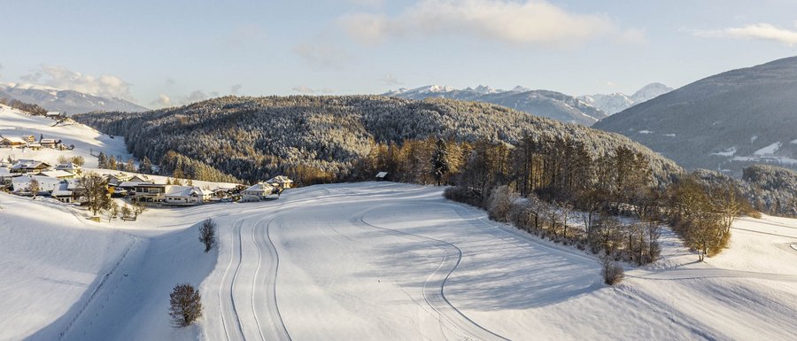Find your accommodation in South Tyrol Snow-covered landscape with mountains and forest in winter