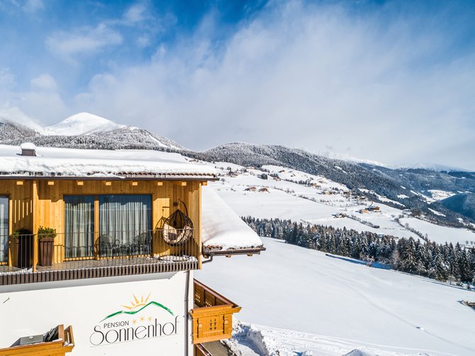 Willkommen in der Ferienregion Gitschberg Jochtal! Die Pension "Sonnenhof" mit einer Schneelandschaft und schneebedeckten Bergen im Hintergrund