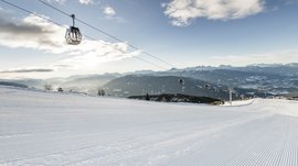 Skigebied Gitschberg Jochtal Lege skipiste met gondellift en bergen op de achtergrond