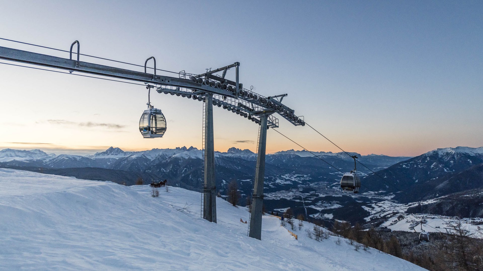 50% adventsspecial Kabelbaan bij zonsondergang boven besneeuwde bergen