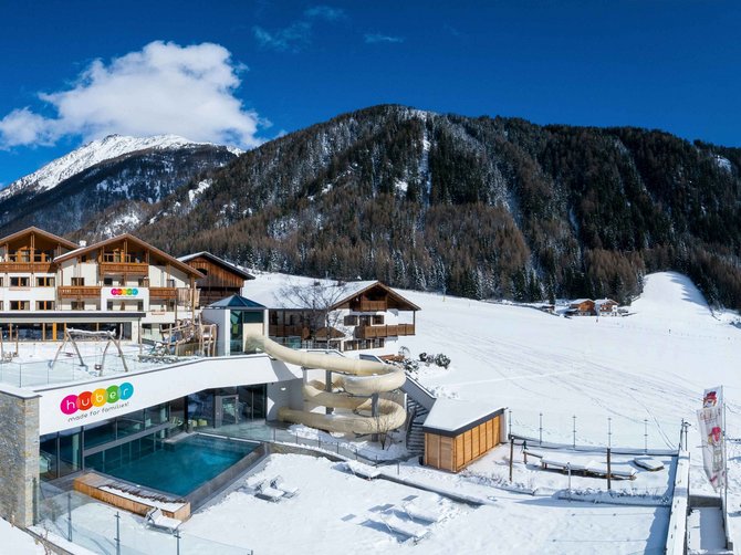 Willkommen in der Ferienregion Gitschberg Jochtal! Familienhotel mit Rutsche und Pool im verschneiten Bergdorf vor Alpenkulisse