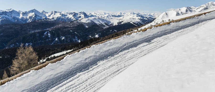 Find your accommodation in South Tyrol Snow-covered ski slope with mountain view and clear sky